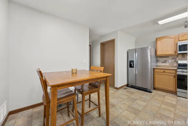 a view of a dining room with furniture and a refrigerator