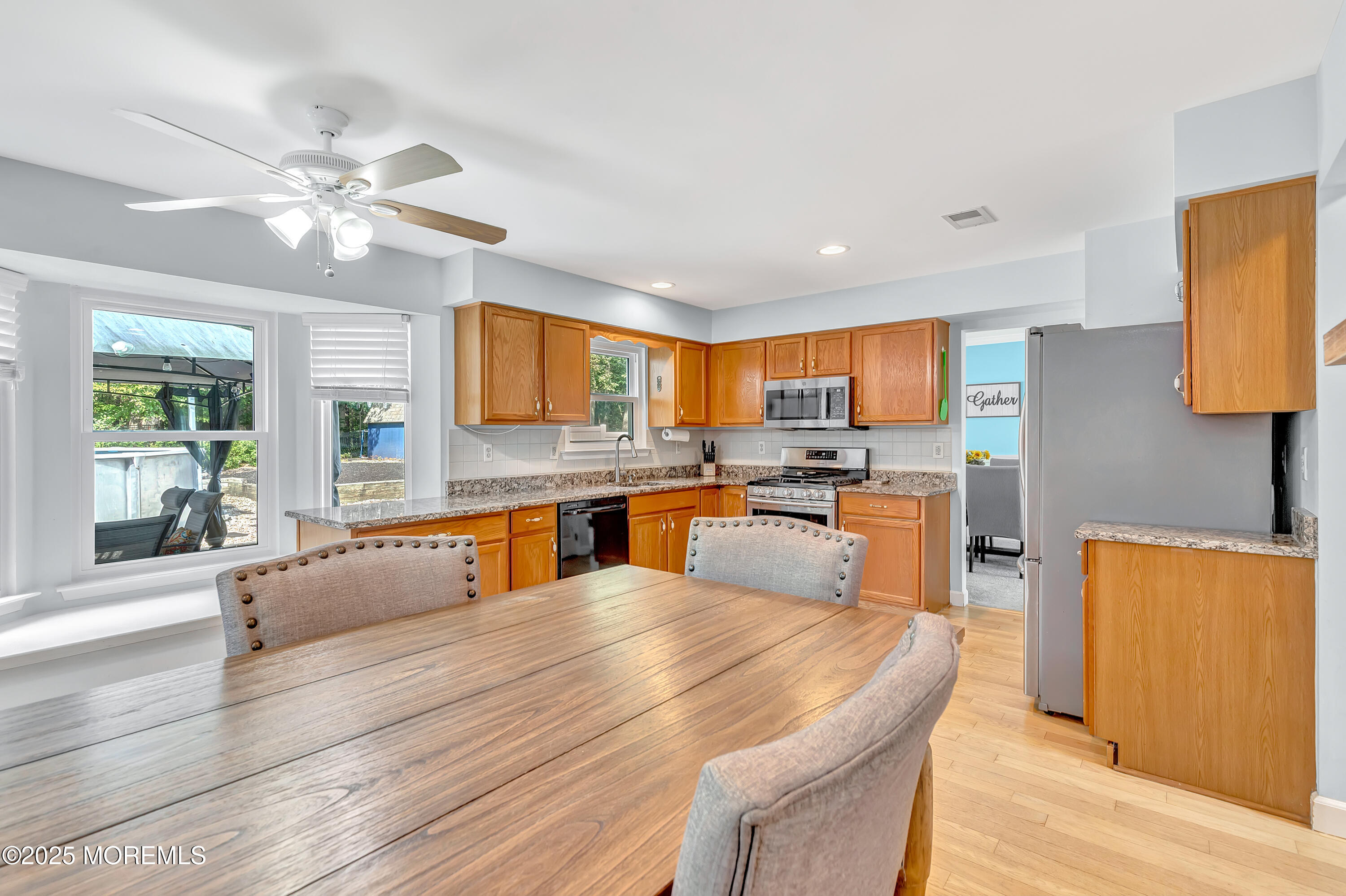 66 Diamond Lane Howell, NJ 07731 - Photo 11 of 47 a large kitchen with stainless steel appliances kitchen island granite countertop a refrigerator a stove a sink dishwasher and white countertops with wooden floor