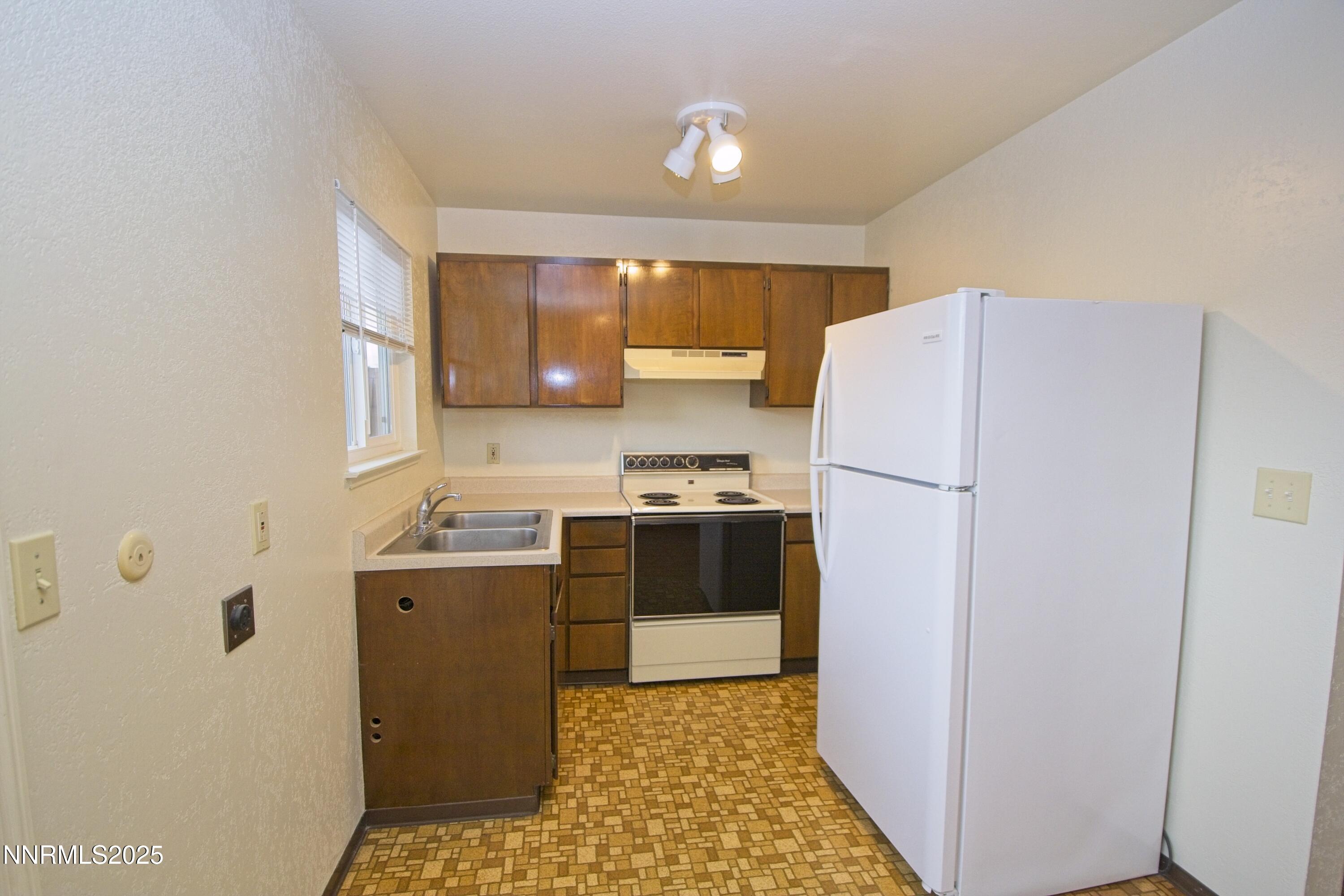 1600 East Long Street Carson City, NV 89706 - Photo 5 of 13 a kitchen with a refrigerator sink stove and cabinets