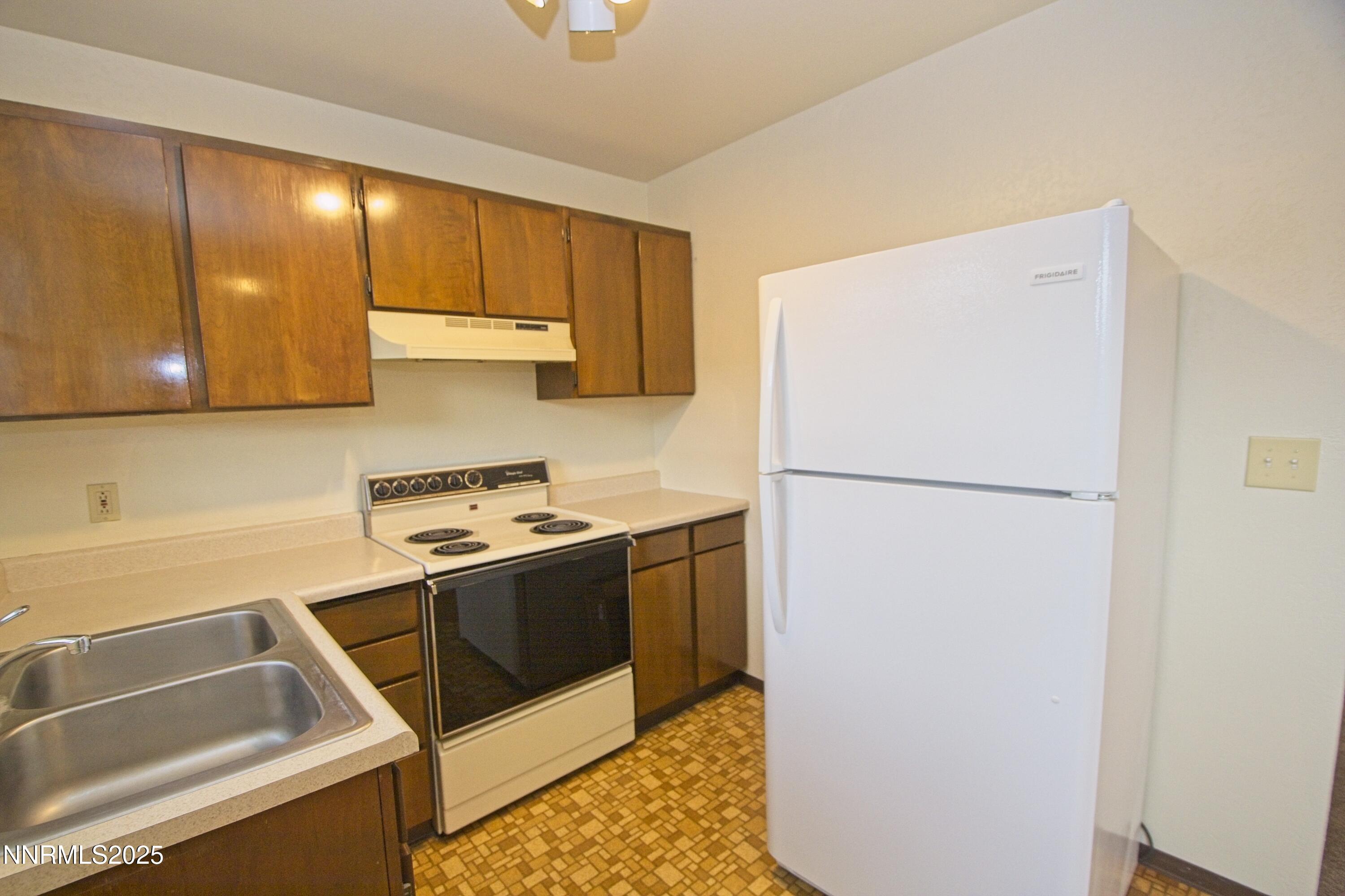 1600 East Long Street Carson City, NV 89706 - Photo 6 of 13 a kitchen with a stove a refrigerator and a sink