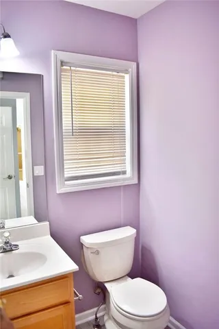 a bathroom with a sink a toilet and a window