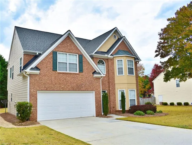 a front view of a house with a yard and garage