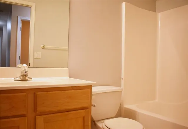 a bathroom with a sink a toilet a mirror and shower
