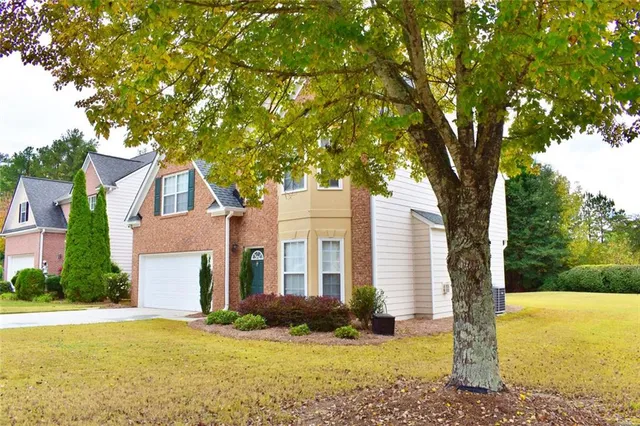 a front view of a house with yard and green space