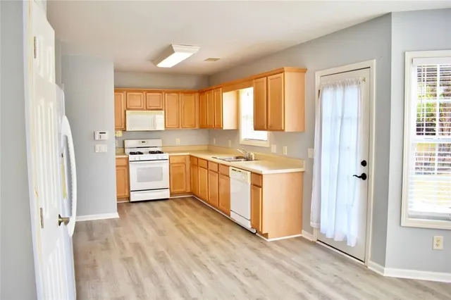a kitchen with stainless steel appliances a white stove top oven and a refrigerator