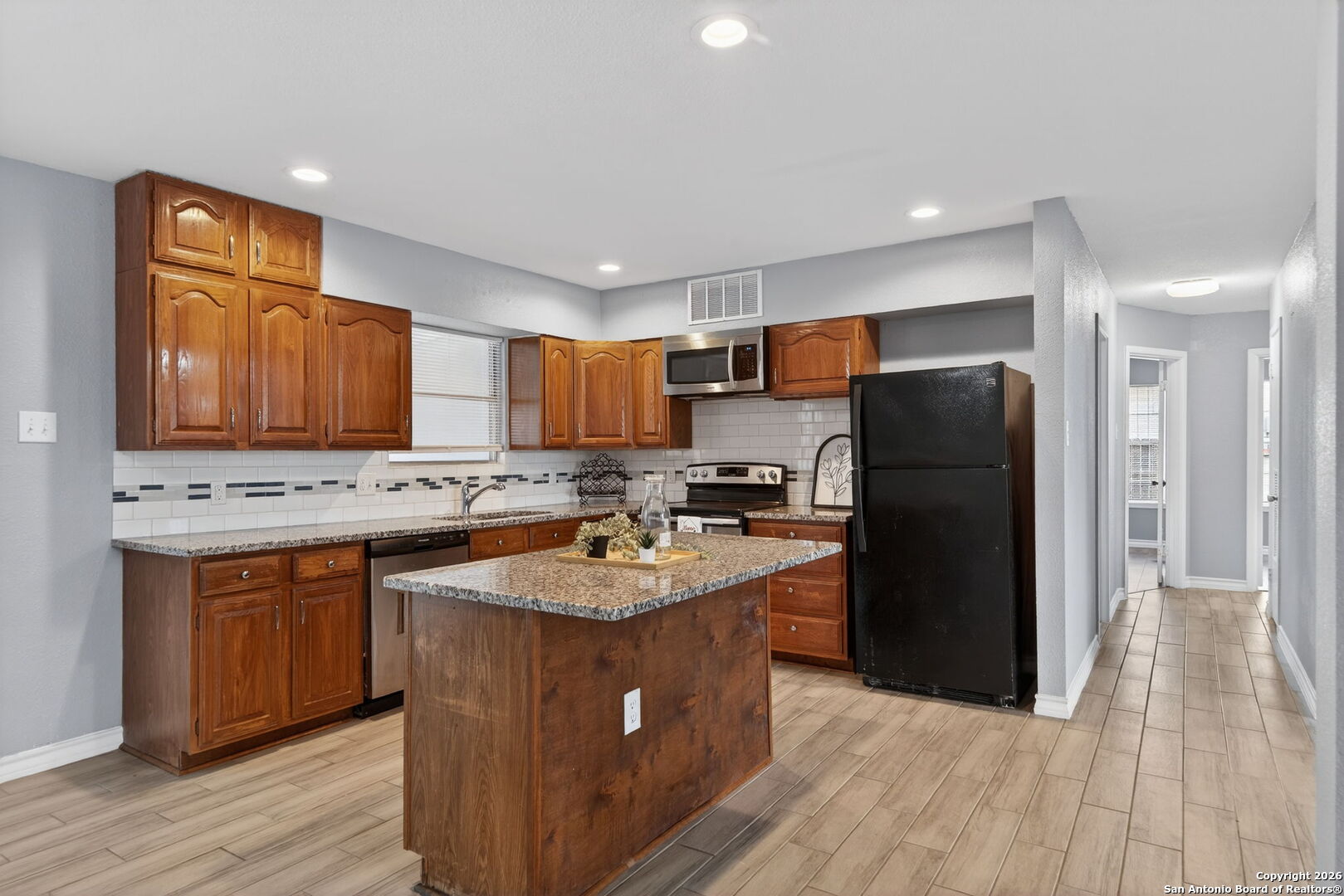 4531 Eisenhauer Road San Antonio, TX 78218 - Photo 11 of 32 a kitchen with a sink a refrigerator a stove and cabinets