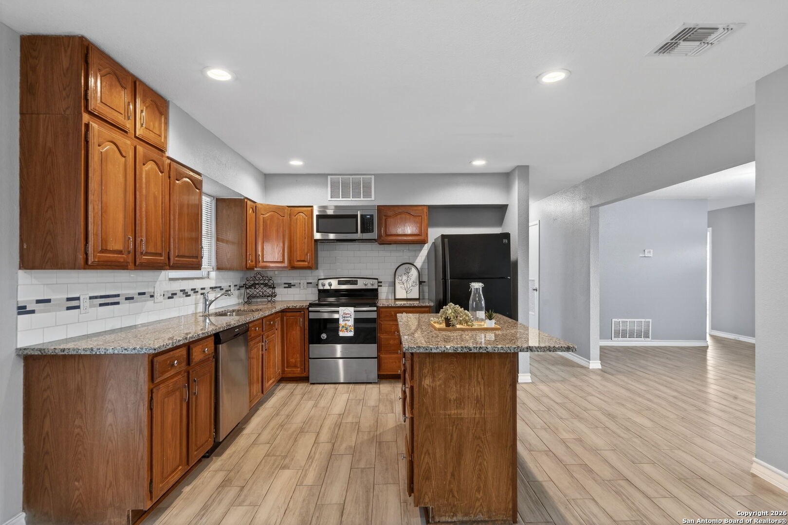 4531 Eisenhauer Road San Antonio, TX 78218 - Photo 12 of 32 a kitchen with stainless steel appliances granite countertop a stove cabinets and wooden floor