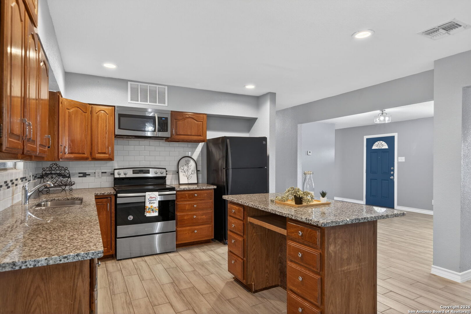 4531 Eisenhauer Road San Antonio, TX 78218 - Photo 13 of 32 a kitchen with stainless steel appliances granite countertop a stove refrigerator and sink