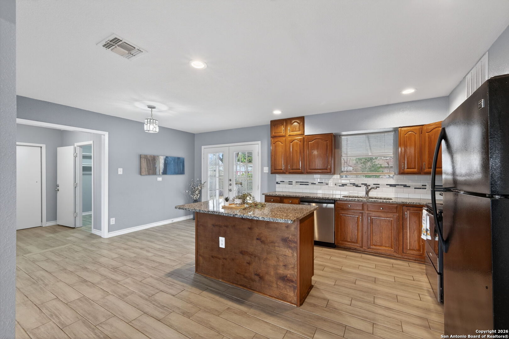 4531 Eisenhauer Road San Antonio, TX 78218 - Photo 14 of 32 a kitchen with stainless steel appliances granite countertop a refrigerator a sink dishwasher a stove with wooden cabinets and floor
