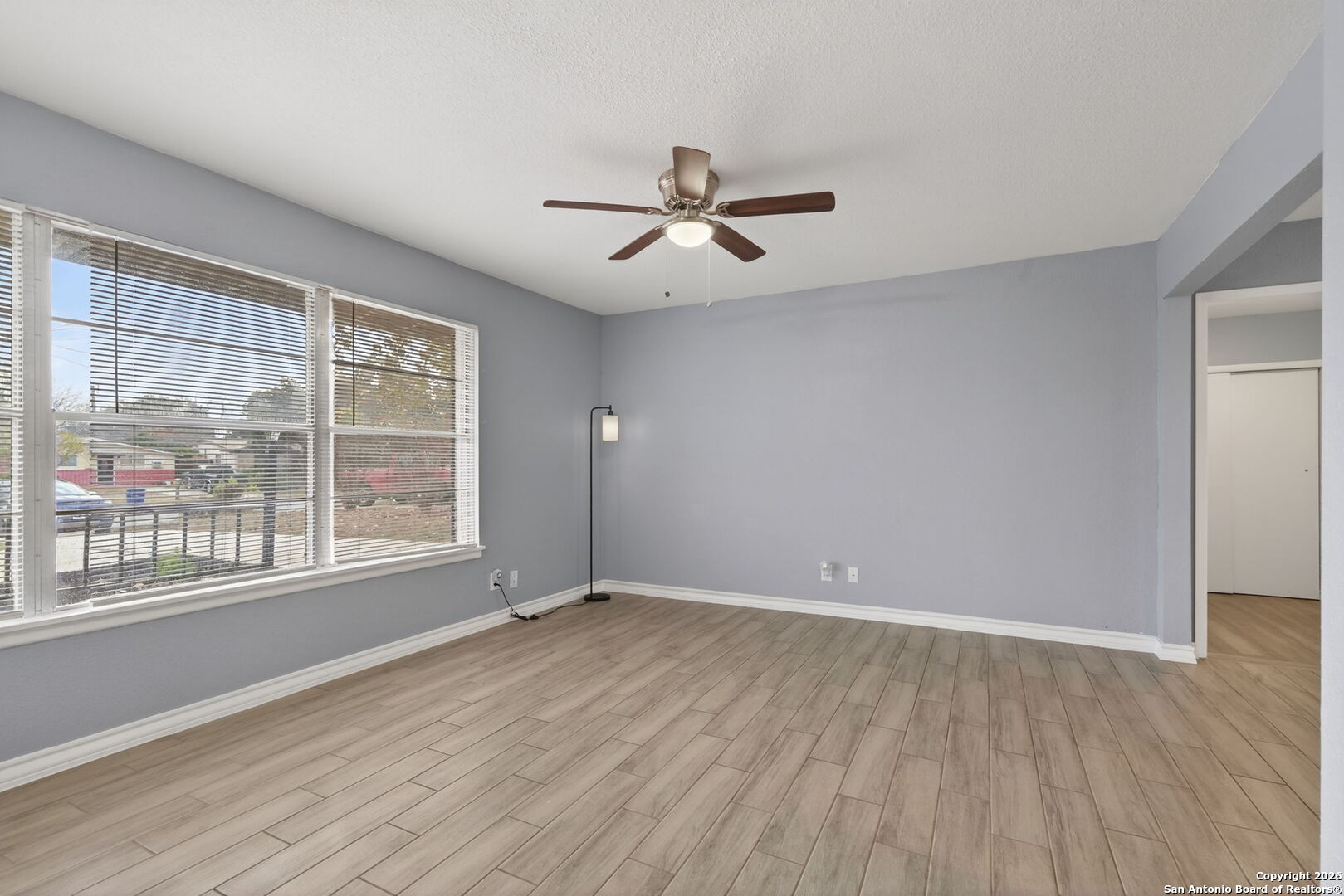 4531 Eisenhauer Road San Antonio, TX 78218 - Photo 6 of 32 an empty room with wooden floor and windows
