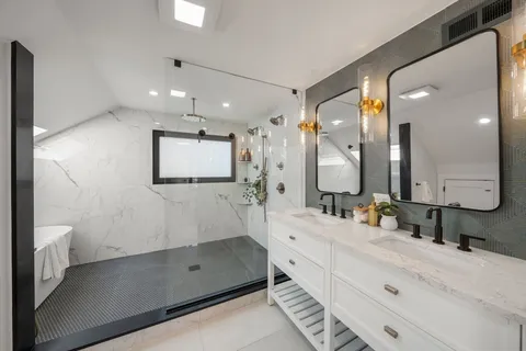 a bathroom with a double vanity sink mirror and shower