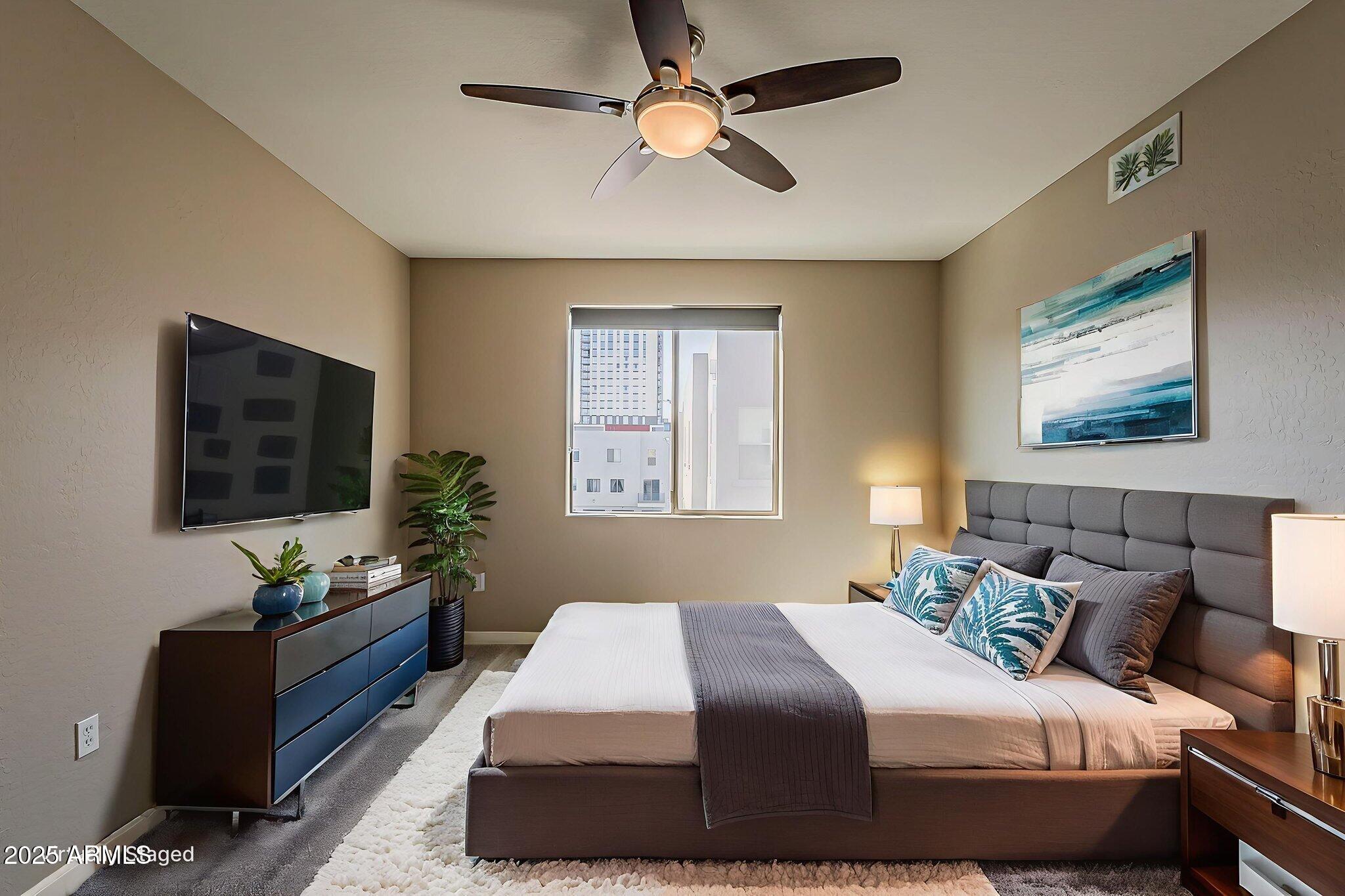 615 East Portland Street, Unit 277 Phoenix, AZ 85004 - Photo 22 of 39 a bedroom with a bed a couch and a flat screen tv