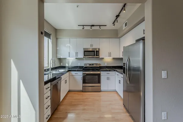 a kitchen with stainless steel appliances granite countertop a stove and a refrigerator