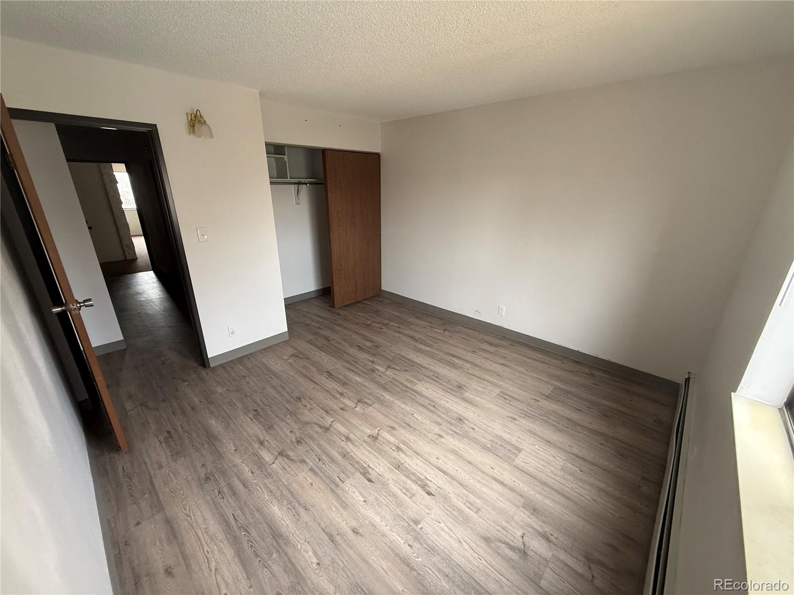 7780 West 38th Avenue, Unit 302 Wheat Ridge, CO 80033 - Photo 11 of 17 an empty room with wooden floor and entrance