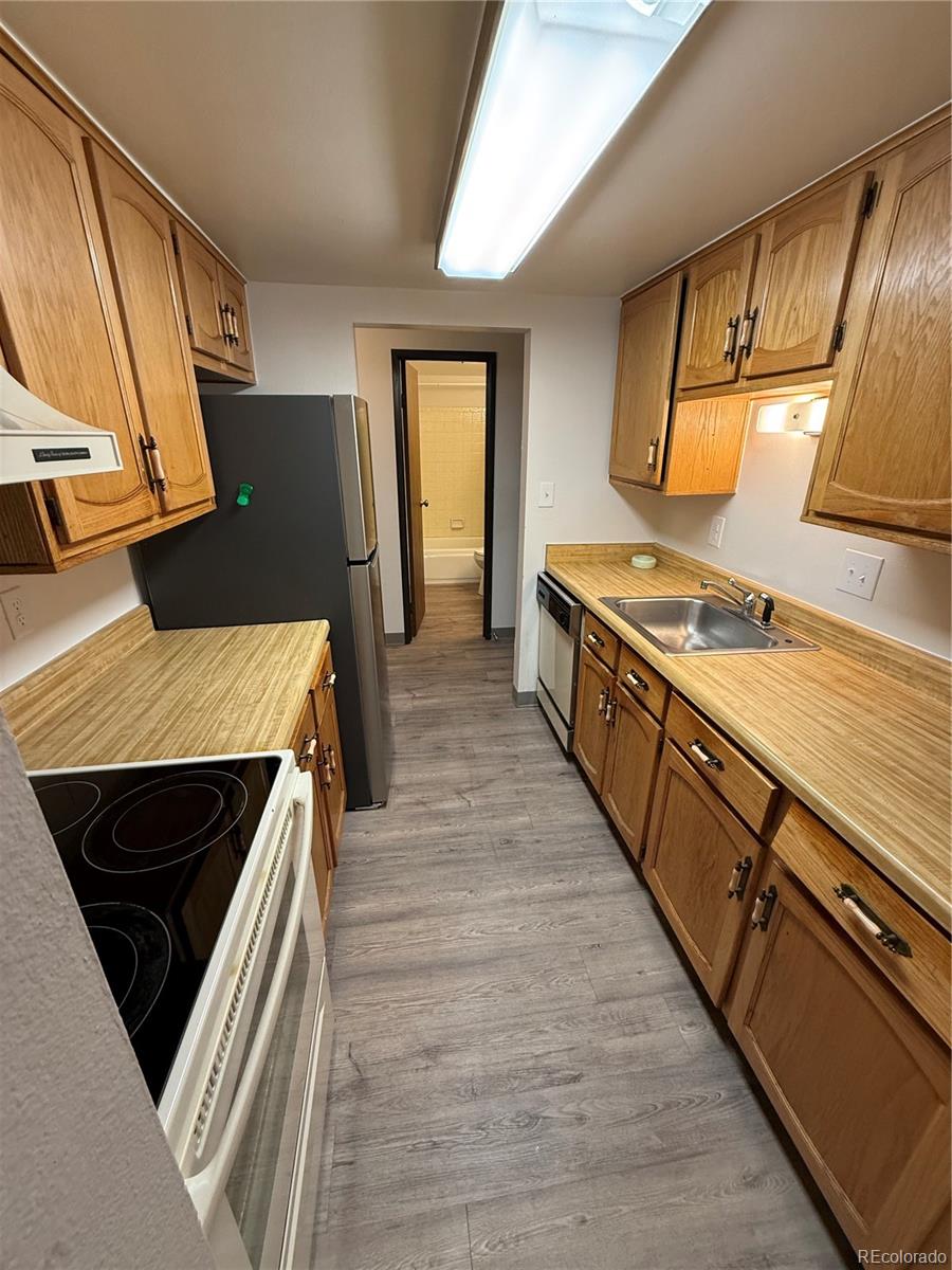 7780 West 38th Avenue, Unit 302 Wheat Ridge, CO 80033 - Photo 15 of 24 a kitchen with wooden cabinets and a stove top oven