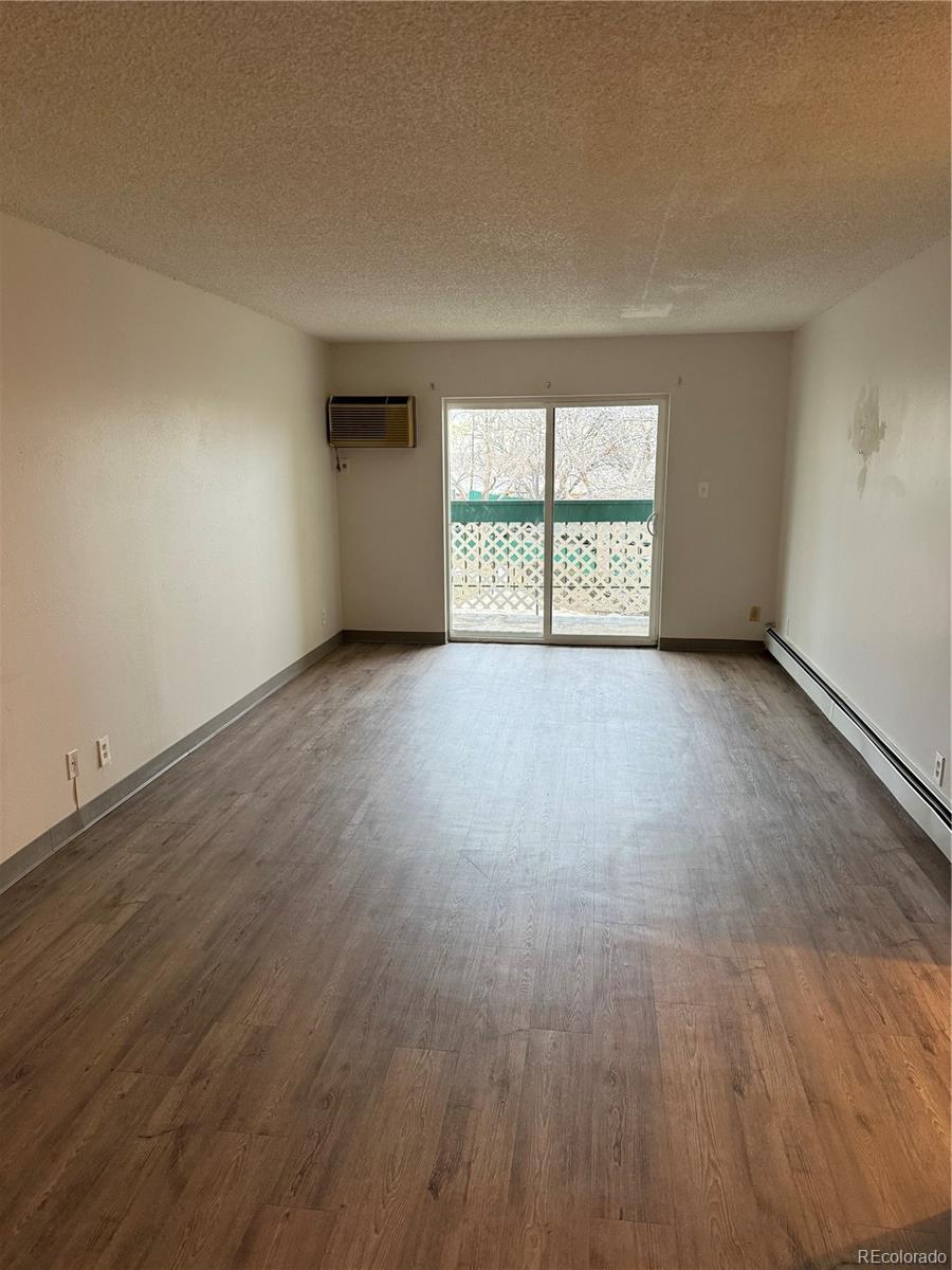 7780 West 38th Avenue, Unit 302 Wheat Ridge, CO 80033 - Photo 20 of 24 an empty room with wooden floor and windows