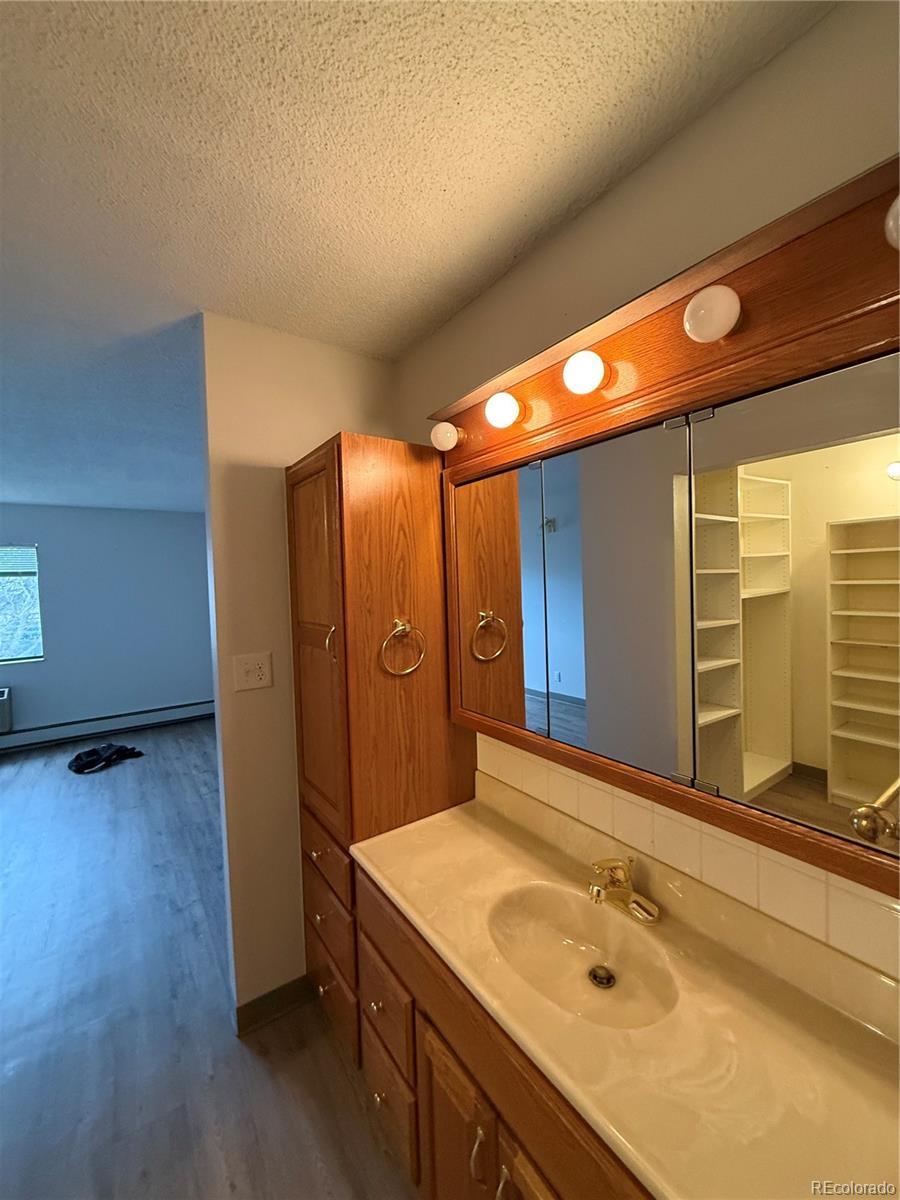 7780 West 38th Avenue, Unit 302 Wheat Ridge, CO 80033 - Photo 7 of 17 a bathroom with a sink mirror and shower