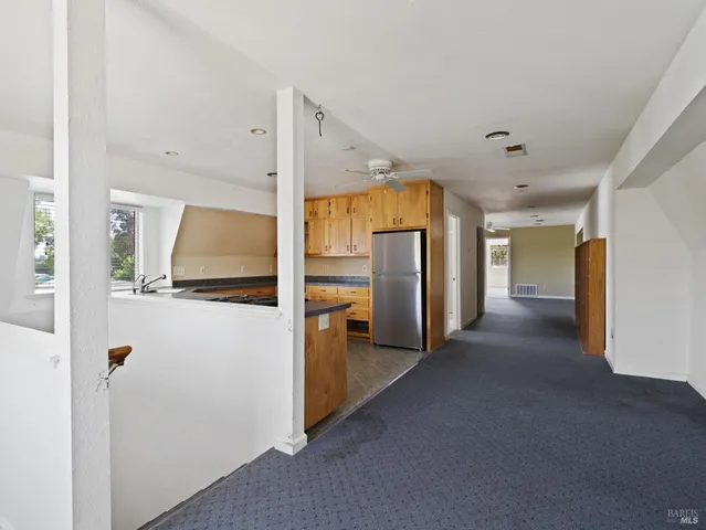 a view of a refrigerator in kitchen and a window