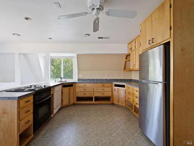 a kitchen with granite countertop a sink stove and refrigerator