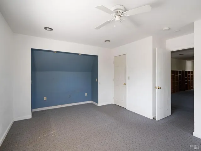 a view of an empty room with a ceiling fan
