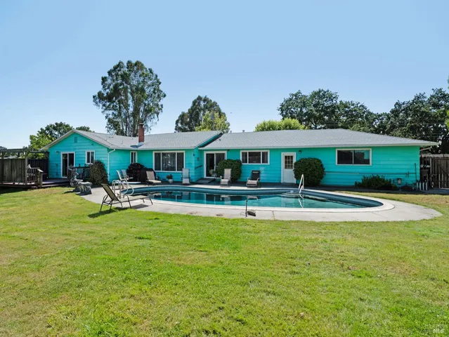 a view of house with swimming pool yard and outdoor seating
