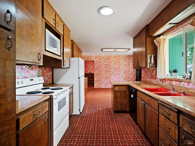 a kitchen with stainless steel appliances a stove a sink and a refrigerator