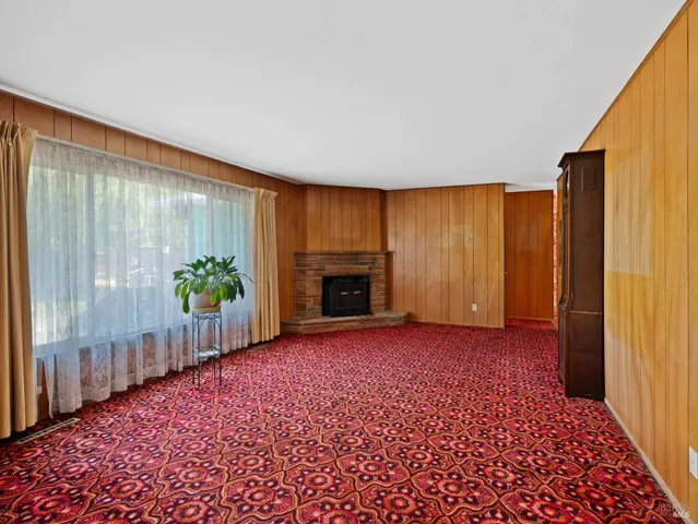 an empty room with windows and a fireplace