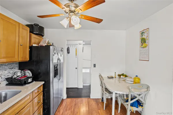 a kitchen with stainless steel appliances granite countertop a refrigerator a stove top oven a chimney and a dining table