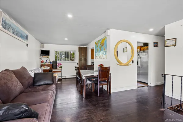 a living room with furniture a clock on wall and a window