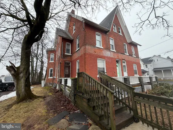 a view of a brick house with iron fence