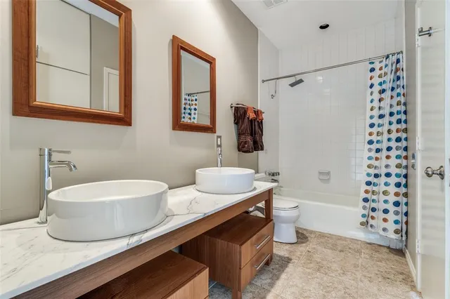 a bathroom with a sink a toilet and shower curtain