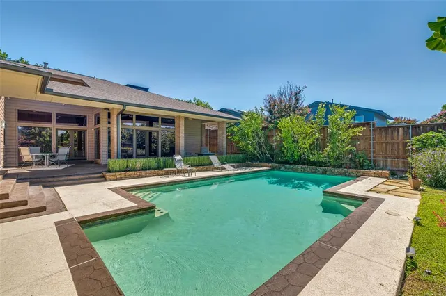 a view of a house with swimming pool and a yard