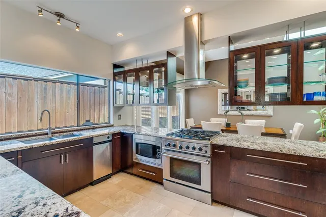a kitchen with stainless steel appliances granite countertop a stove sink and cabinets