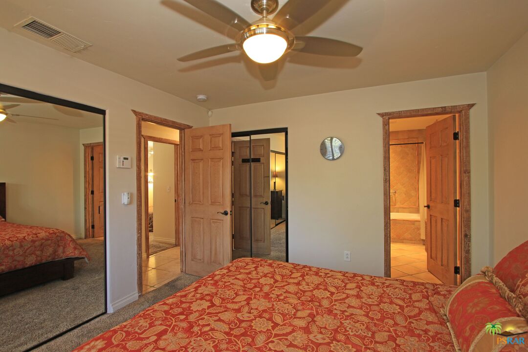 2288 North Deborah Road Palm Springs, CA 92262 - Photo 23 of 33 a bedroom with a bed and a chandelier