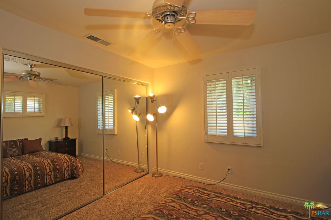 2288 North Deborah Road Palm Springs, CA 92262 - Photo 26 of 33 a bedroom with a bed and a chandelier
