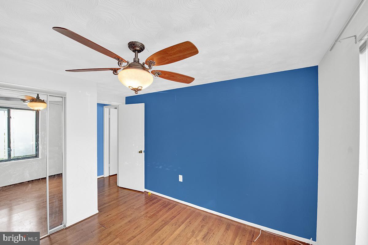 13257 Wonderland Way, Unit 1101 Germantown, MD 20874 - Photo 36 of 51 an empty room with wooden floor and ceiling fan