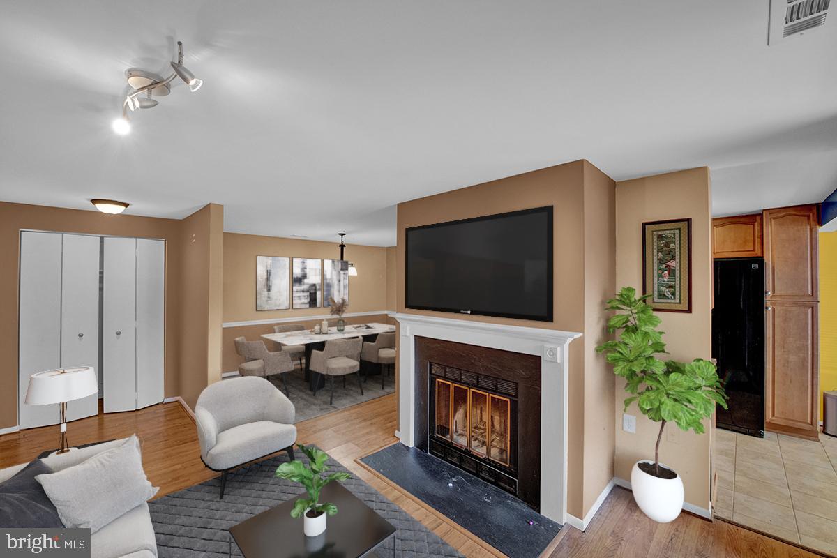 13257 Wonderland Way, Unit 1101 Germantown, MD 20874 - Photo 4 of 51 a living room with furniture a flat screen tv and a fireplace