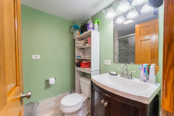 a bathroom with a sink vanity mirror and toilet