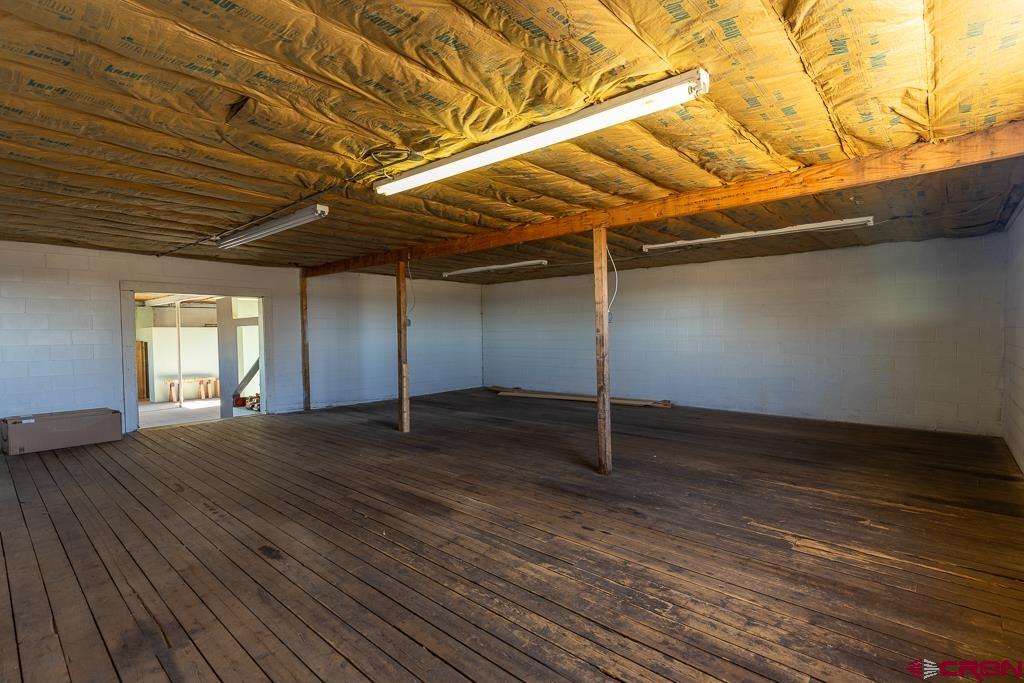 27 South Broadway Cortez, CO 81321 - Photo 27 of 35 an empty room with wooden floor and windows