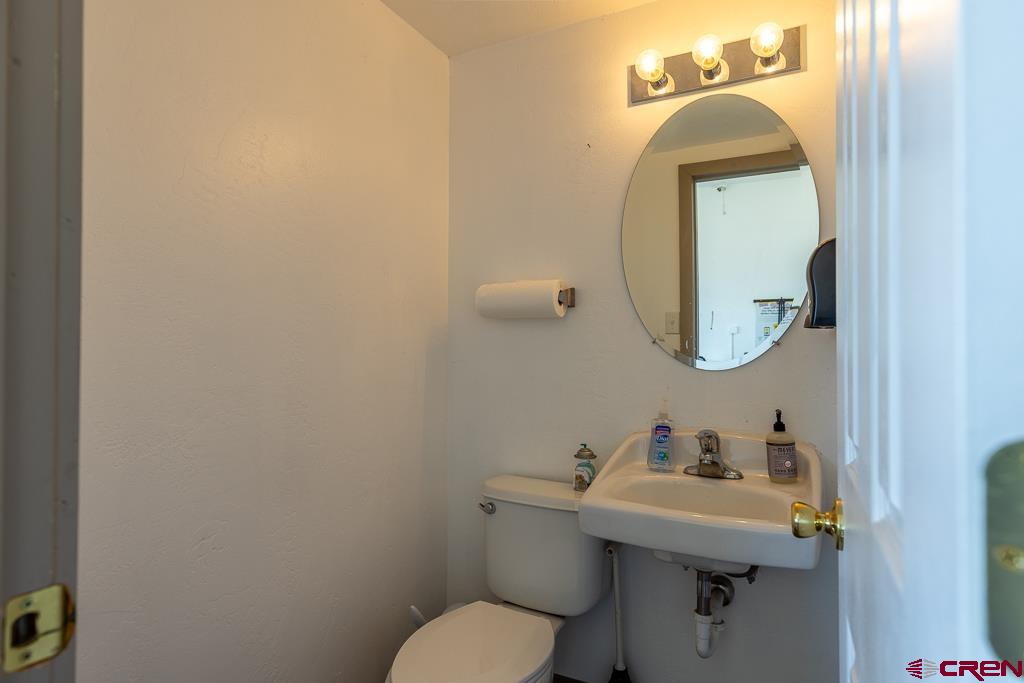 27 South Broadway Cortez, CO 81321 - Photo 9 of 35 a bathroom with a toilet sink and mirror