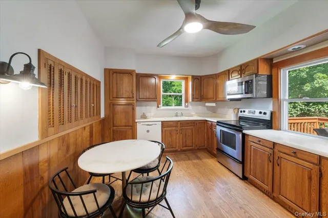 a kitchen with stainless steel appliances kitchen island granite countertop a sink a stove a dining table and chairs