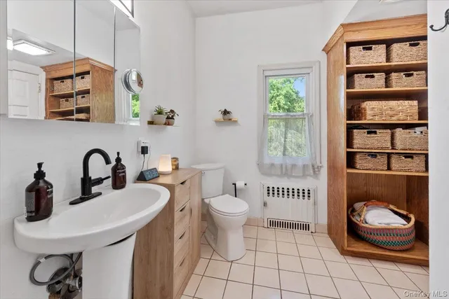 a bathroom with a sink a toilet and a window