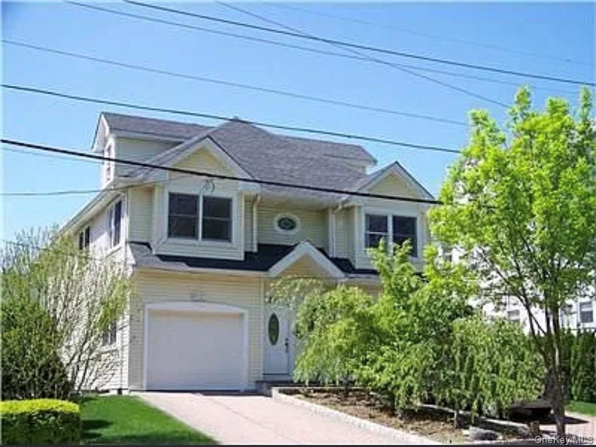 View of front facade with concrete driveway and an attached garage