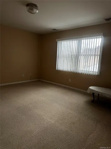an empty room with a chair and windows