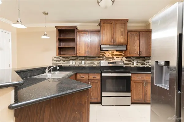 a kitchen with kitchen island granite countertop wooden cabinets and a stainless steel appliances