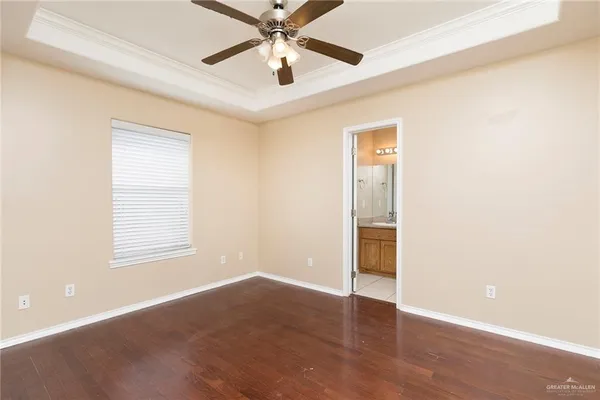 an empty room with wooden floor closet and windows