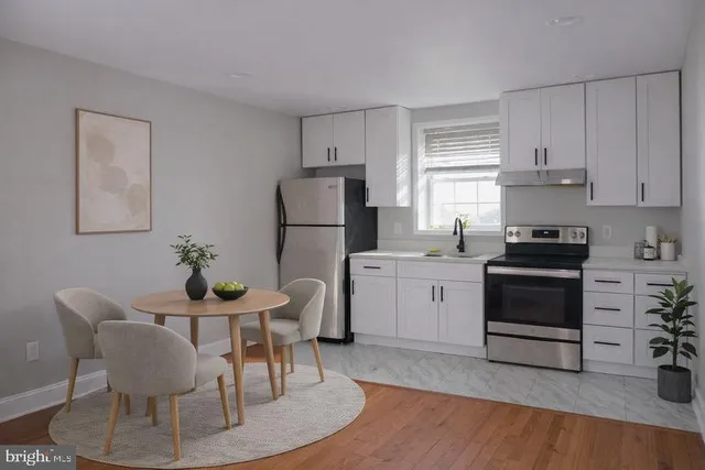 a kitchen with a stove a refrigerator and a dining table