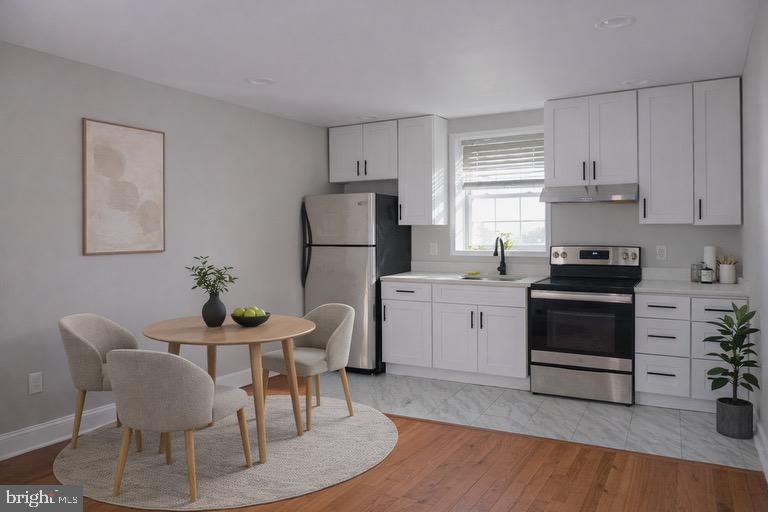 5538 Master Street Philadelphia, PA 19131 - Photo 3 of 30 a kitchen with a stove a refrigerator and a dining table