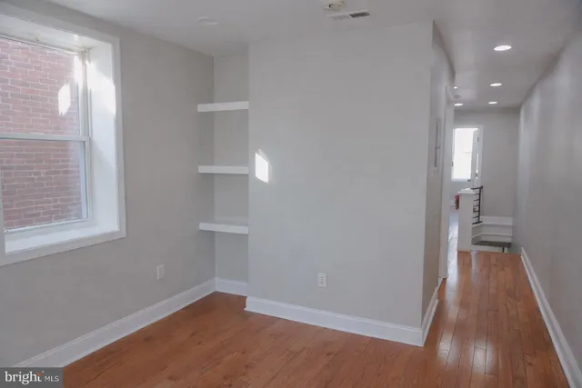 a view of a room with wooden floor and a window