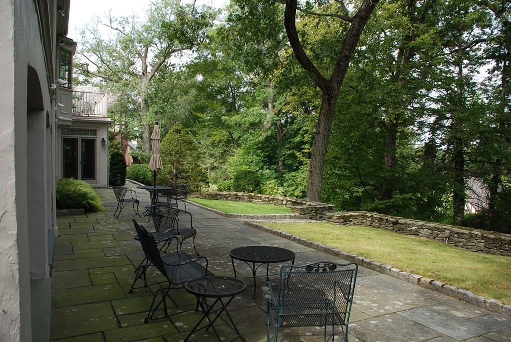 46 Chestnut Hill Road Newton, MA 02467 - Photo 4 of 5 a view of a patio with table and chairs and potted plants with large tree